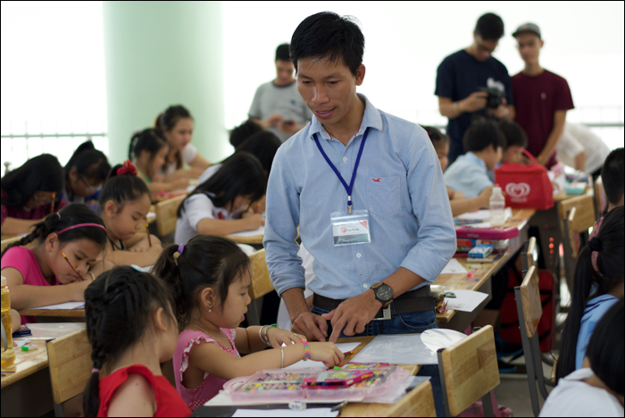 Thầy Hồng lớp vẽ OS hướng dẫn các em trong cuộc thi Doodle 4 Google do Google tổ chức (ảnh http://www.techsignin.com/cong-nghe/ngay-hoi-doodle-4-google-uoc-mo-cua-em/) — tại Nhà Thiếu Nhi - Quận Đoàn 10.